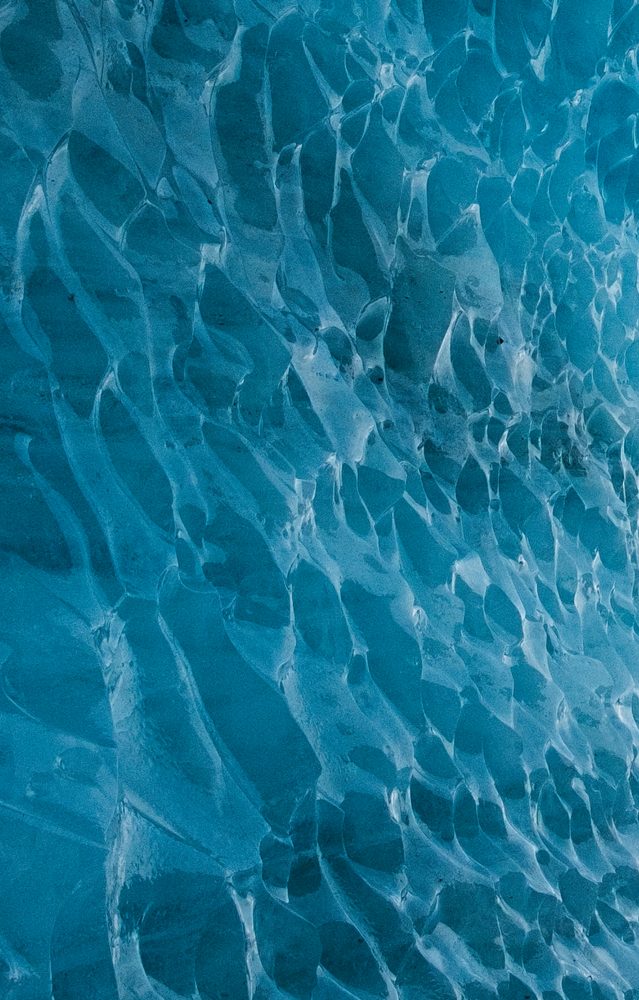 Close view of rippled blue ice with a scalloped, wind carved texture.